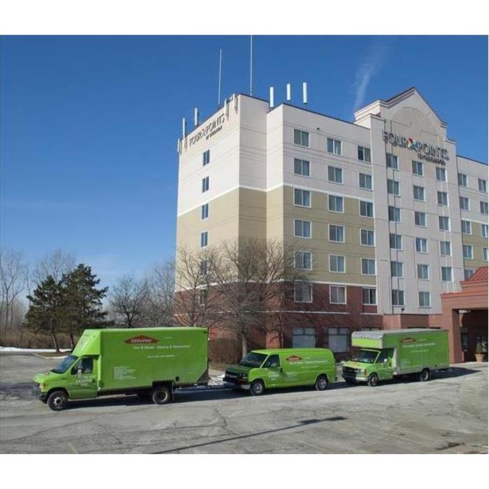 Three SERVPRO vehicles parked in front of a hotel