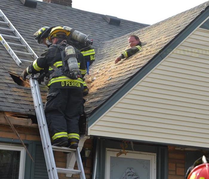 Three firefighters on roof